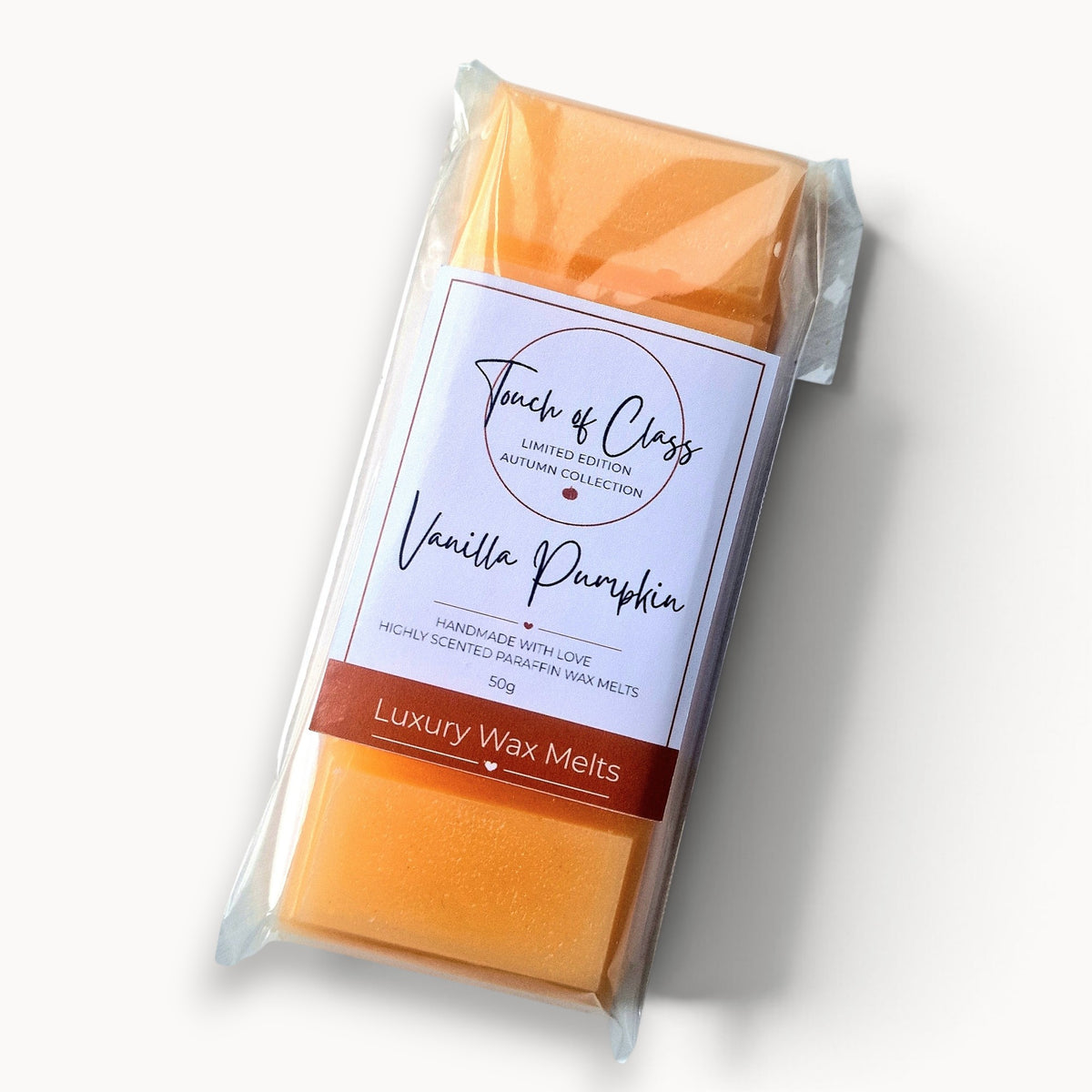A packaged bar of wax melts from Touch of Class, specifically 'Vanilla Pumpkin' scent, in a clear plastic sleeve with a white and brown paper label, set against a clean white background.